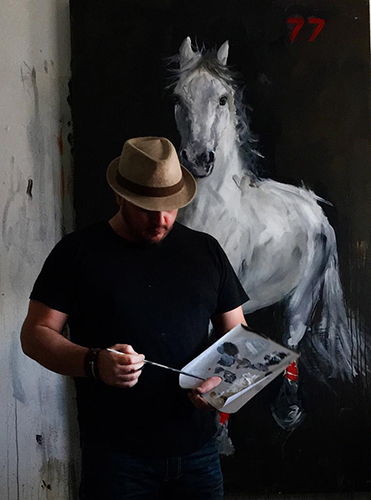 Abraham Mojica comtemplating while painting